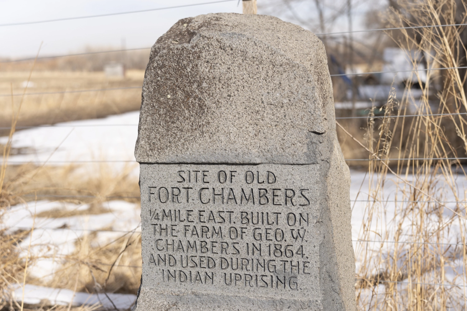 Stone marker reading 'Site of Old Fort Chambers' near Boulder, Colorado — the training ground for men who participated in the 1864 Sand Creek Massacre.
